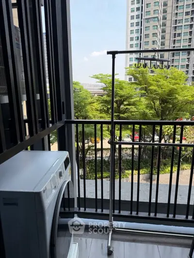 Modern balcony with washing machine and scenic view of lush greenery and urban skyline.