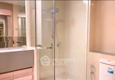 Modern bathroom with glass shower and sleek fixtures in a contemporary apartment.
