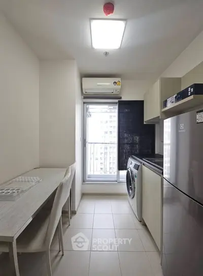 Modern kitchen with washing machine and fridge in compact apartment