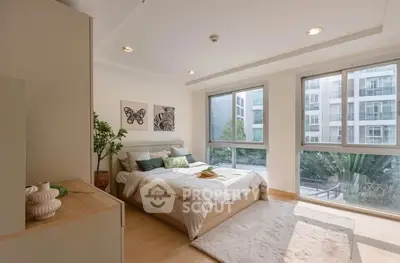 Spacious bedroom with large windows and modern decor in a luxury apartment.