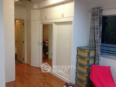 Spacious bedroom with built-in wardrobe and wooden flooring