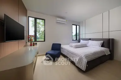 Modern bedroom with stylish decor and natural light, featuring a comfortable bed and sleek furnishings.