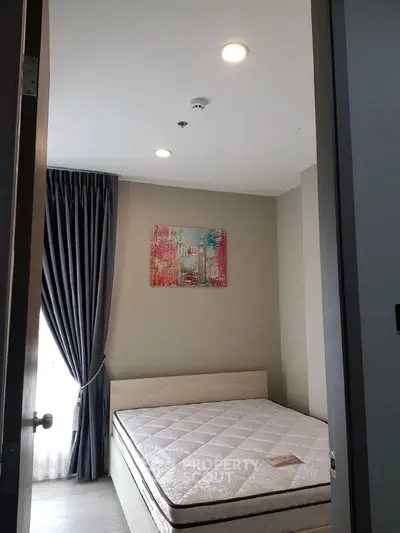 Cozy bedroom with modern decor and natural light, featuring a comfortable bed and stylish artwork.