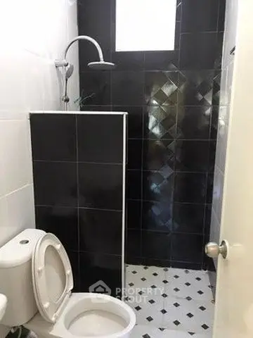 Modern bathroom with sleek black tiles and contemporary fixtures.
