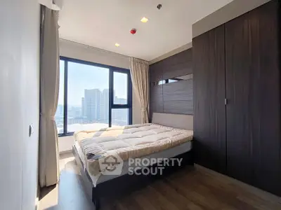 Modern bedroom with large windows and city view, featuring sleek dark wood wardrobe and cozy bed.