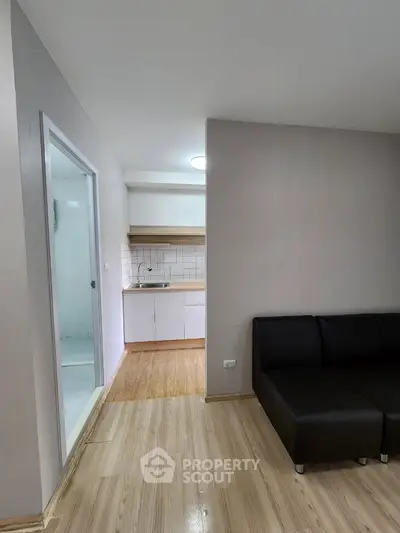 Modern apartment interior with sleek kitchen and cozy living area, perfect for urban living.