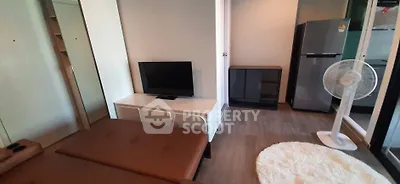 Modern living room with sleek furniture and stylish decor, featuring a TV and a cozy seating area.