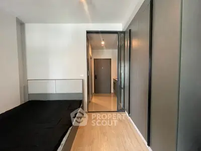Modern bedroom with sleek design and wooden flooring in a contemporary apartment.
