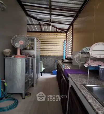 Charming narrow kitchen with rustic metal roof and practical storage solutions