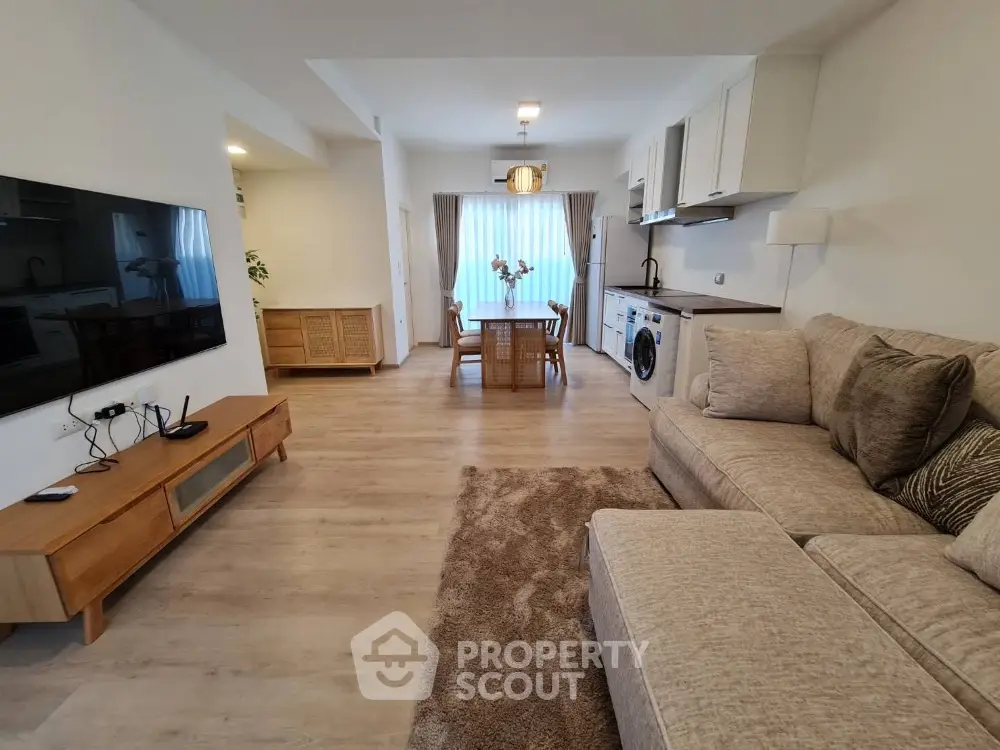Spacious open-plan living room with modern furniture and kitchen appliances, perfect for family gatherings.