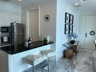 Modern kitchen with sleek black countertops and white cabinetry, featuring stainless steel appliances and elegant decor.