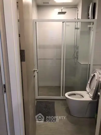 Modern bathroom with glass shower enclosure and sleek toilet design.
