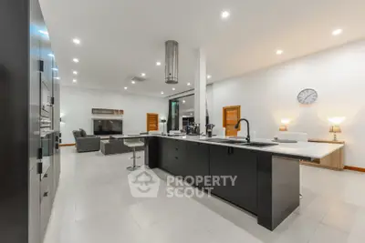 Spacious modern kitchen with sleek black island and open layout to living area