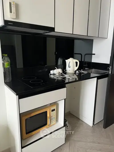 Modern kitchen with sleek black countertops and built-in microwave
