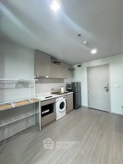 Modern kitchen with sleek appliances and ample storage in a stylish apartment.