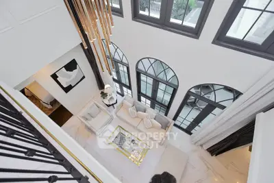 Luxurious high-ceiling living room with elegant decor and large windows