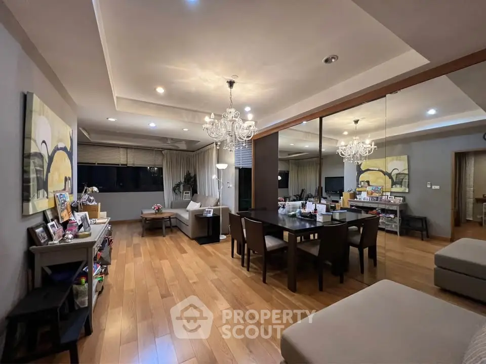 Spacious modern living room with elegant chandelier and wooden flooring