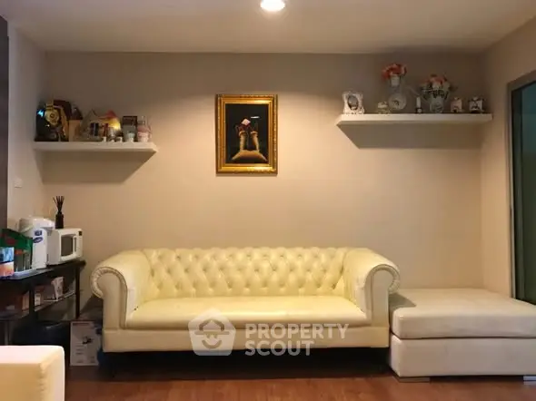 Charming living room with elegant white sofa and decorative shelves, perfect for cozy gatherings.