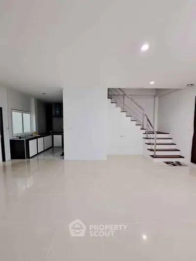 Spacious modern interior with sleek staircase and open kitchen layout, perfect for contemporary living.