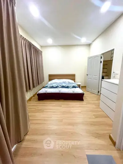 Spacious bedroom with wooden flooring and modern decor