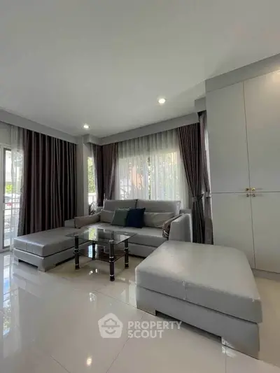 Spacious modern living room with elegant decor and large windows for natural light.