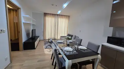 Modern dining and living area with sleek furniture and natural light
