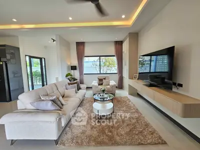 Spacious modern living room with elegant decor and large windows offering natural light.