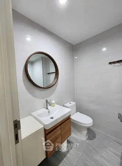 Modern bathroom with sleek fixtures and round mirror in a contemporary home.