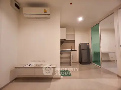 Modern studio apartment with sleek kitchen and air conditioning, perfect for urban living.