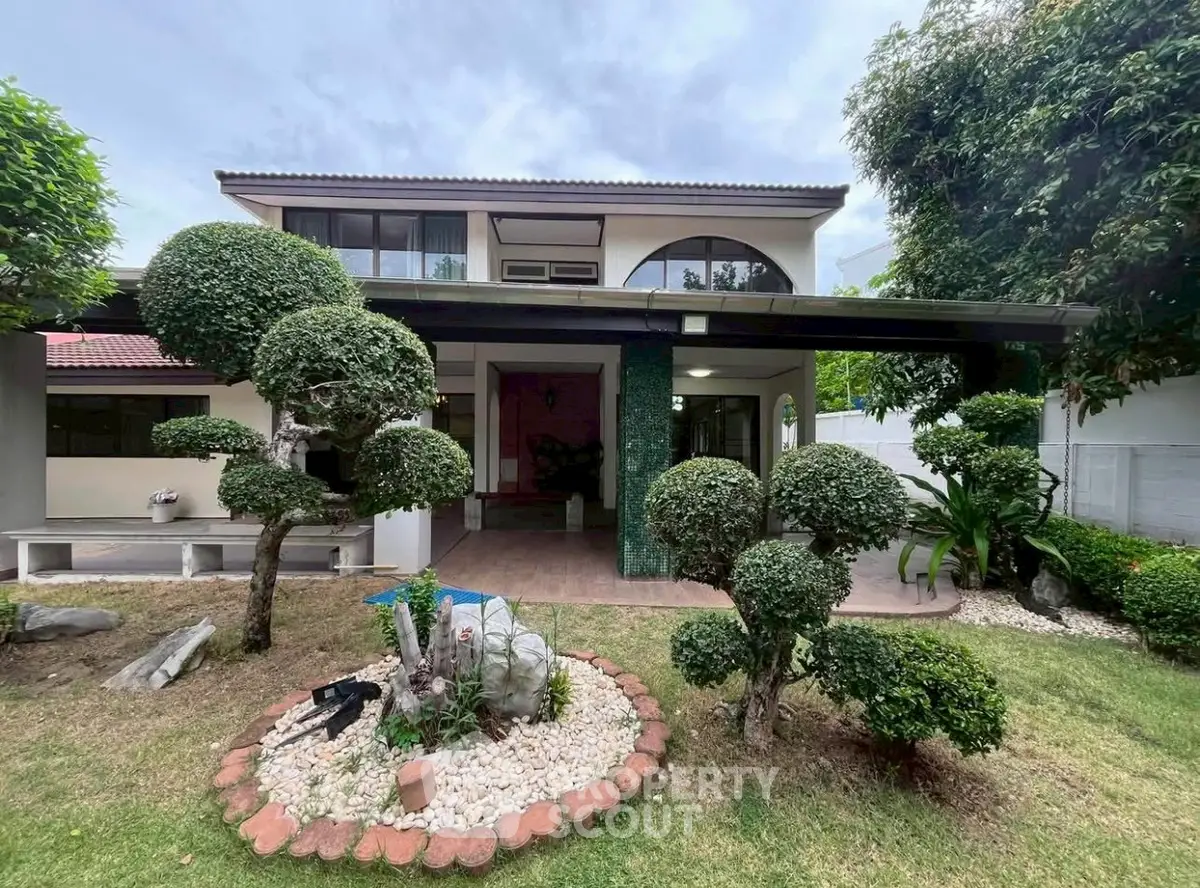 Charming two-story home with manicured garden and spacious patio, perfect for family living.