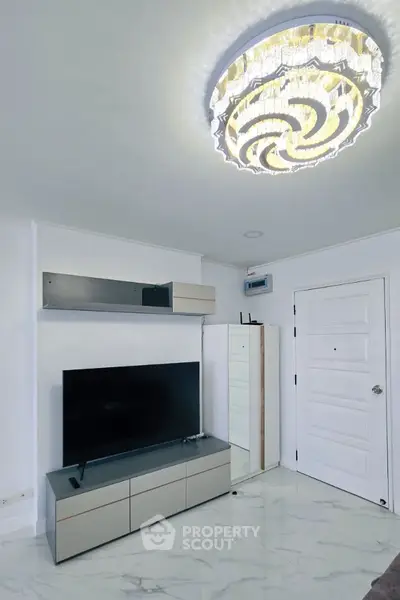 Modern living room with sleek TV unit and elegant chandelier