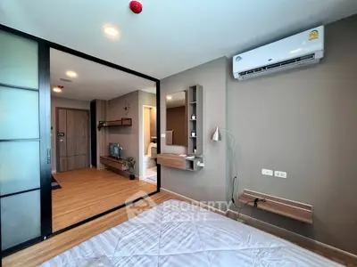 Modern bedroom with sliding glass doors and air conditioning in stylish apartment.