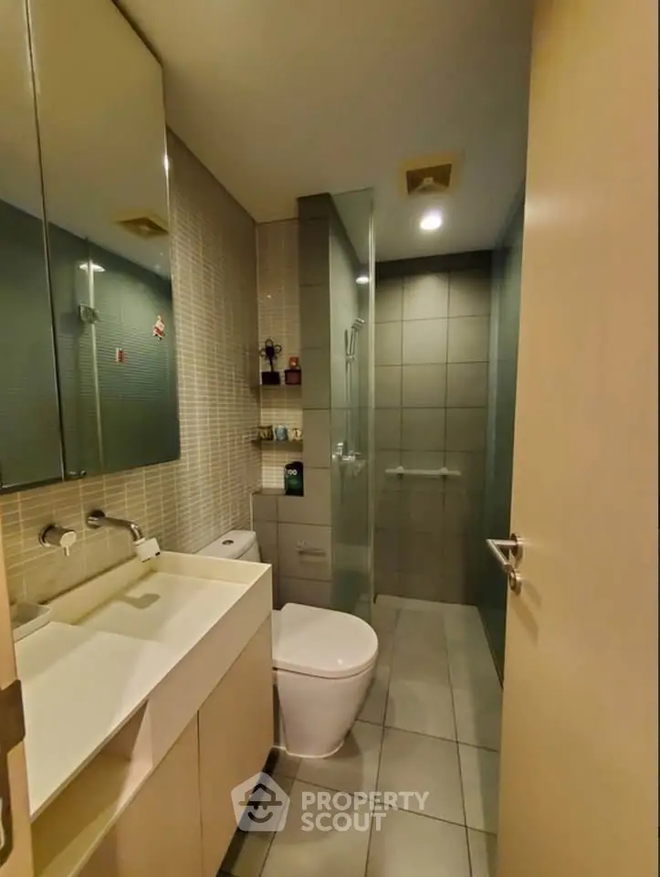 Modern bathroom with sleek design, glass shower, and stylish fixtures in a contemporary apartment.