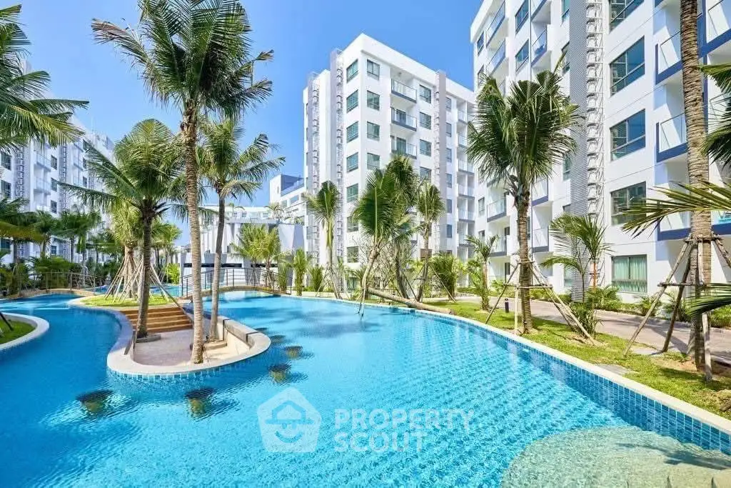 Luxurious apartment complex with stunning pool and lush palm trees.