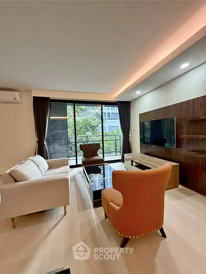 Spacious modern living room with elegant furniture and large windows offering natural light.