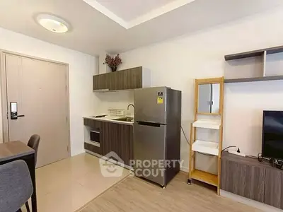 Modern compact kitchen with sleek cabinets and stainless steel fridge in cozy apartment.