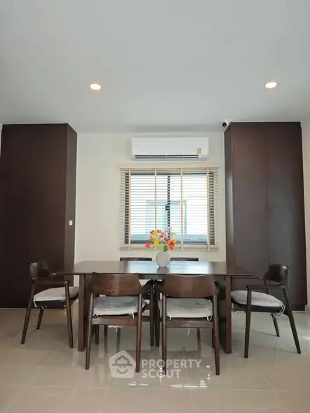 Modern dining area with sleek wooden furniture and air conditioning