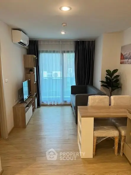 Modern living room with wooden flooring, cozy sofa, and dining area in a stylish apartment.