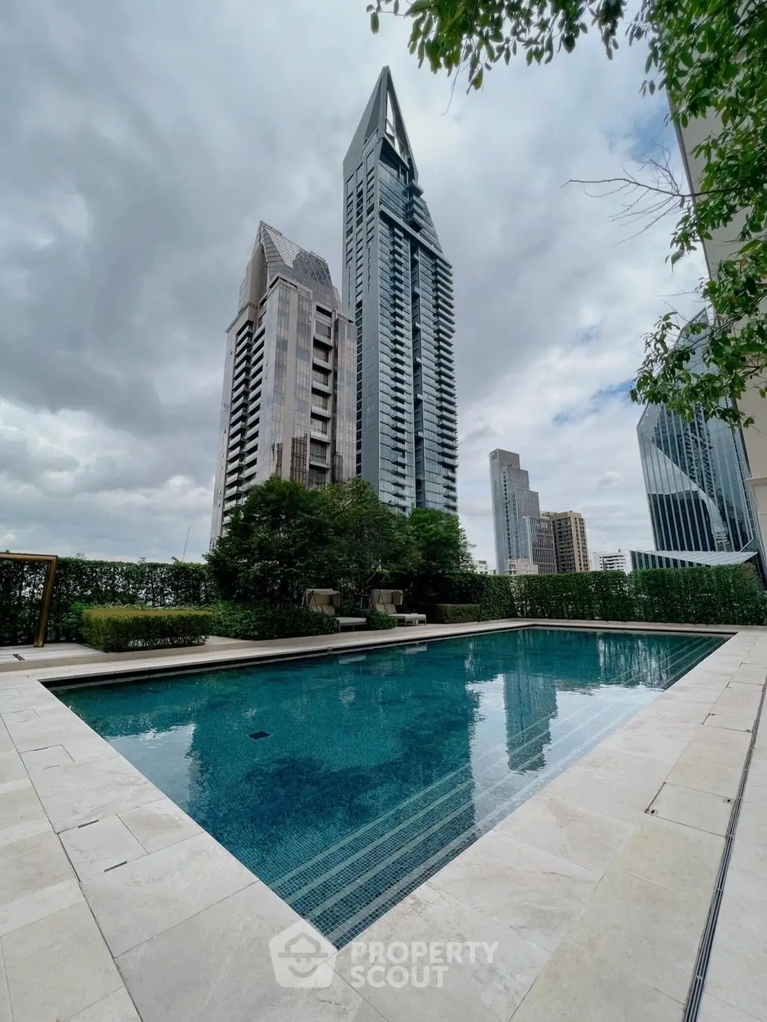 Luxurious high-rise building with a stunning pool and cityscape view, perfect for urban living.