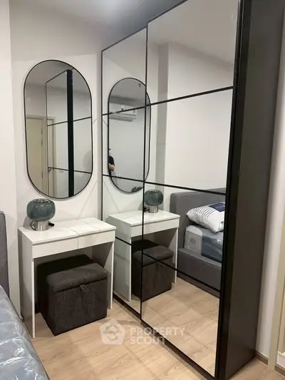 Modern bedroom with mirrored wardrobe and stylish vanity area