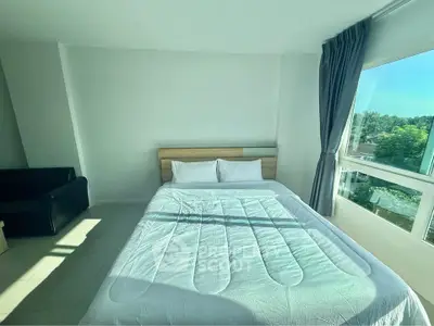 Bright bedroom with large window and cozy bed in modern apartment