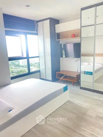 Modern bedroom with large window and mirrored wardrobe in a high-rise apartment.