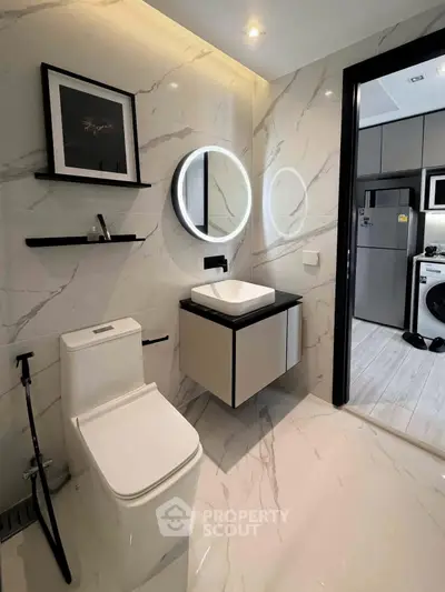 Luxurious modern bathroom with sleek fixtures and elegant marble tiles, featuring a stylish circular mirror and contemporary design.