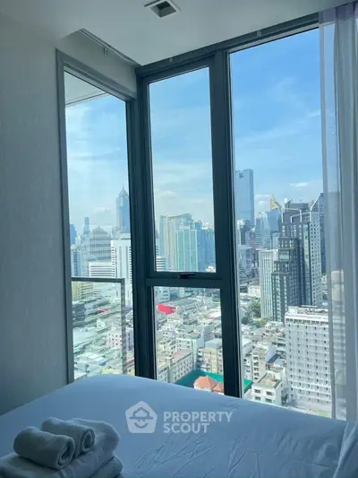 Stunning bedroom with panoramic city view in modern high-rise apartment.