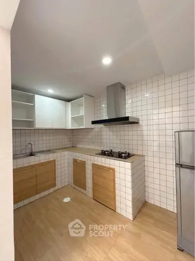 Modern kitchen with sleek cabinetry and gas stove in a stylish real estate property.