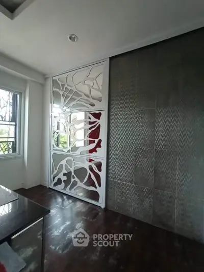 Modern interior with artistic partition and textured wall in a stylish living space.