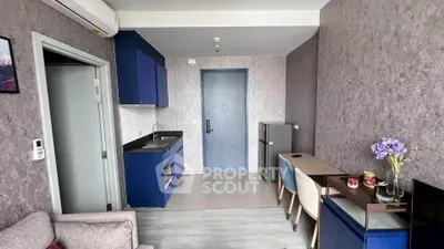 Modern living room with blue cabinetry and stylish decor in a compact apartment.