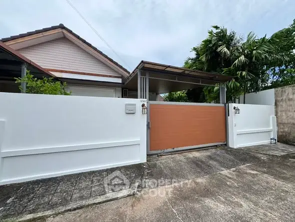 Charming suburban home with gated entrance and lush greenery, perfect for family living.