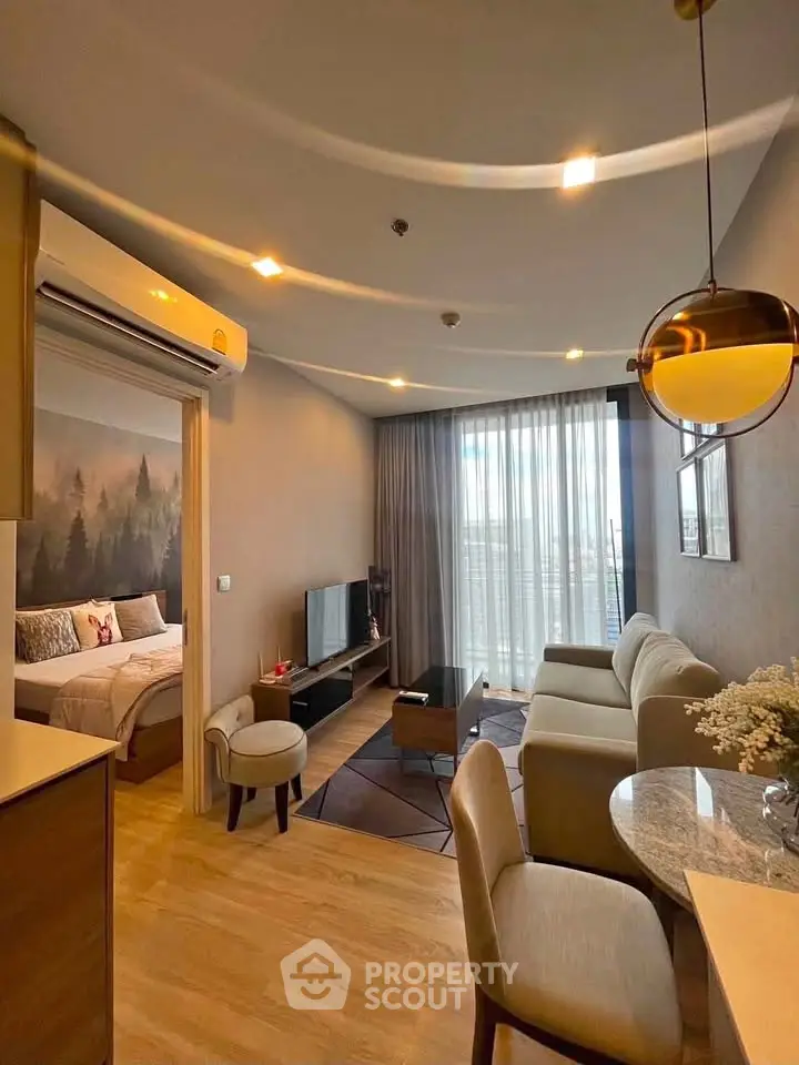 Modern living room with open layout, cozy seating, and natural light from large windows.