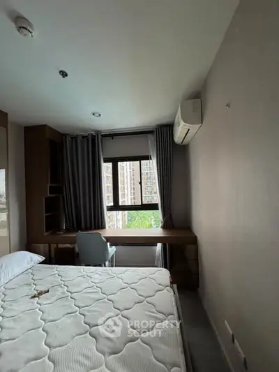 Modern bedroom with large window and air conditioning in urban apartment.